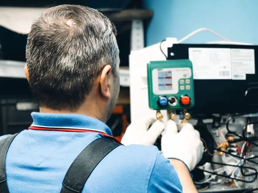 Técnico de refrigeração trabalhando com manifold em ar condicionado